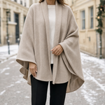 Aldbury Knit Cape in taupe worn with black trousers, front view