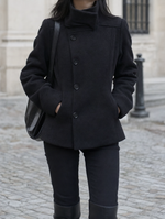 Bramhall Funnel Neck Coat in black worn with black trousers, front view